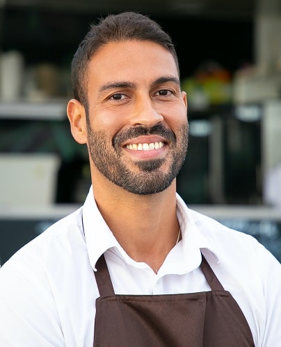 A smiling restaurant owner inviting to his restaurant