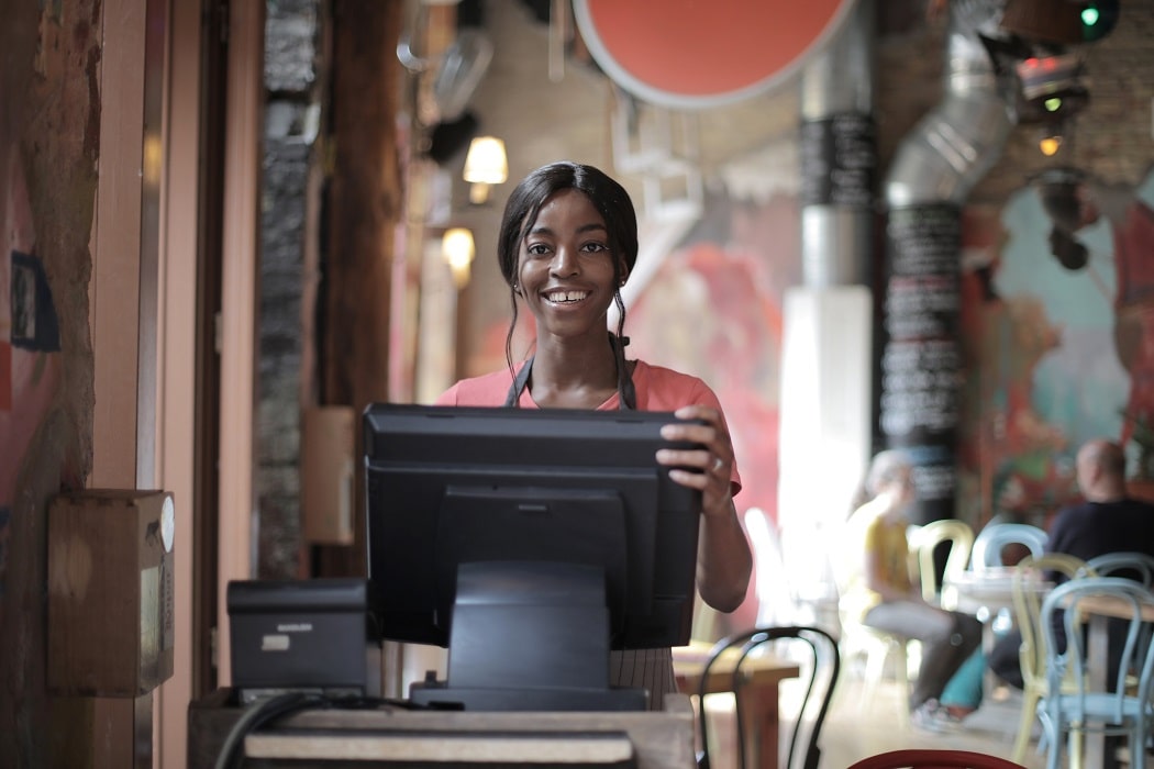 Cheerful waitress standing at counter